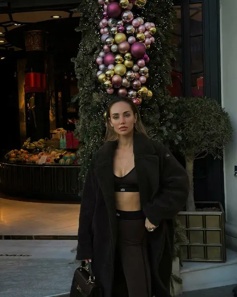 image by abrilraluy containing woman, stand, black, christmas tree, coat