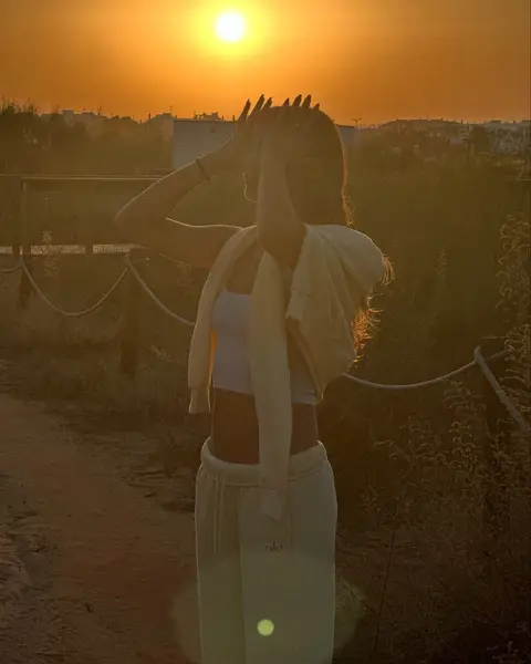 image by sarasampaio containing woman, sun, sunset, stand, hand